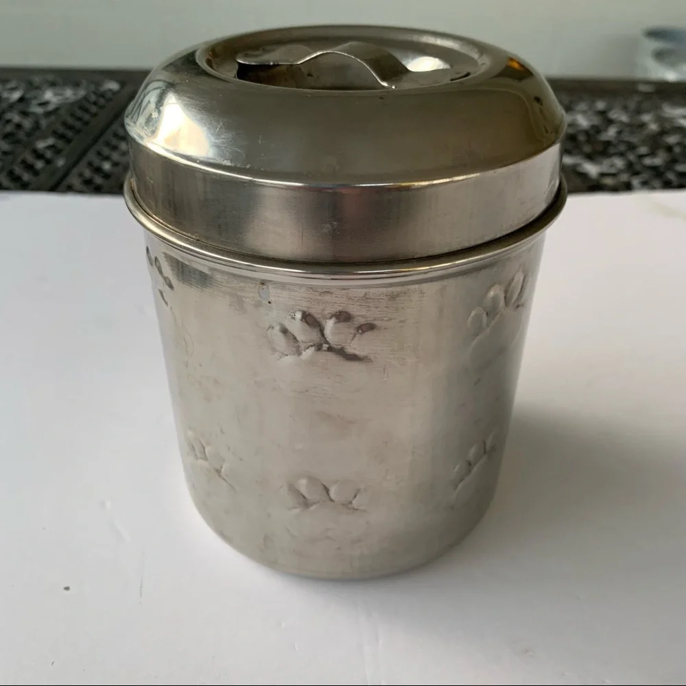 Dog treat canister with paw prints to keep small dog treats